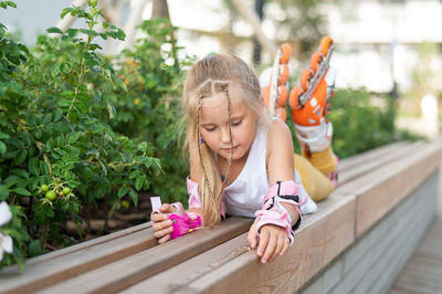 Girl lying by plants wearing inline skates