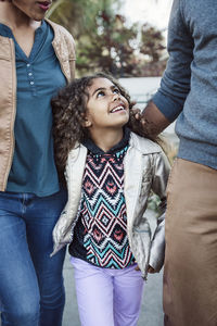 Daughter walking with parents on footpath