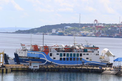 Boats moored at harbor against sky