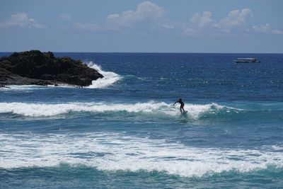 Man surfing in sea against sky