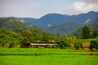 Built structure on field by mountains against sky
