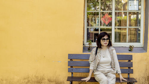 Portrait of woman against wall