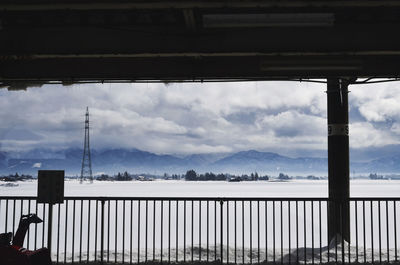 Railing by mountain against sky