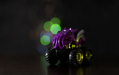 Close-up of toy car on table against black background