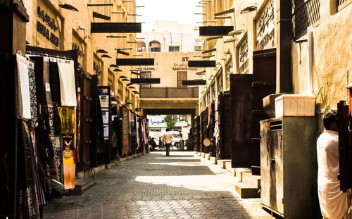 People on narrow street amidst buildings in city