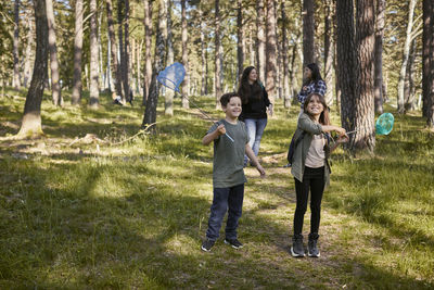 Full length of friends standing in forest