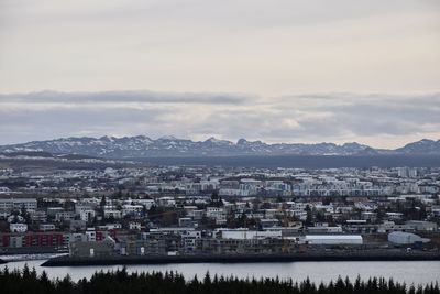 High angle view of townscape by sea against sky