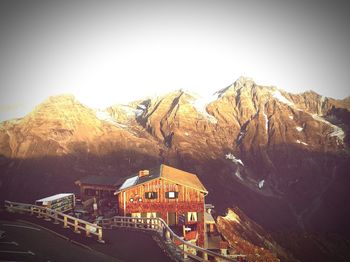 Building by mountain against sky