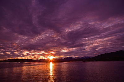 Scenic view of dramatic sky over lake during sunset