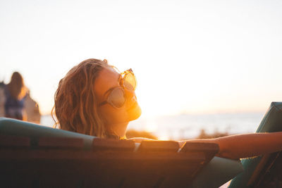 Rear view of woman sitting at beach