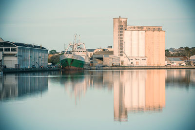 Reflection of buildings in river against sky