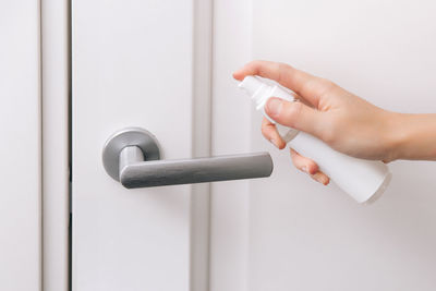 Close-up of human hand cleaning door