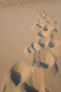 High angle view of footprints on sand at beach