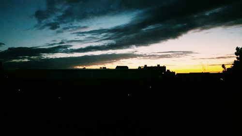 Silhouette of built structures against dramatic sky