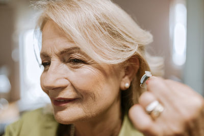 Senior woman applying hearing aid