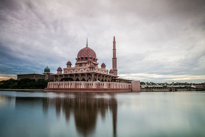 Reflection of putra mosque in lake against cloudy sky