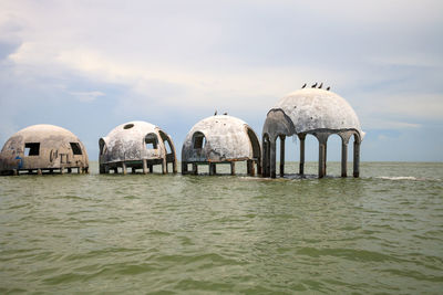 Gazebo in sea against sky