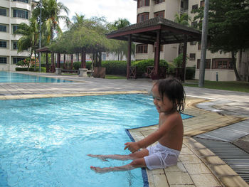 Cheerful girl sitting on poolside