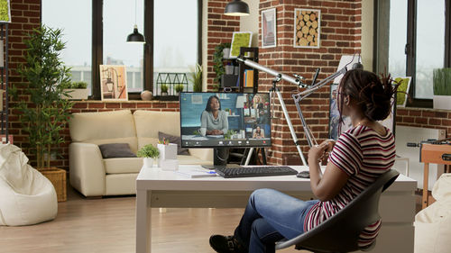 Young woman using mobile phone while sitting on sofa