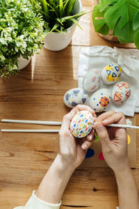 Female painting a modern easter eggs. brushes and paints with flowers and plants. happy easter 