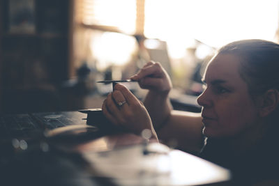 Craftsman woman works with decoration, makes the base of copper metal under the enamel, the concept 