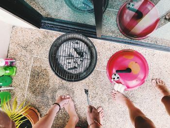 Friends preparing barbecue grill at home