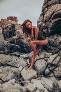 Woman standing on rock against rocks