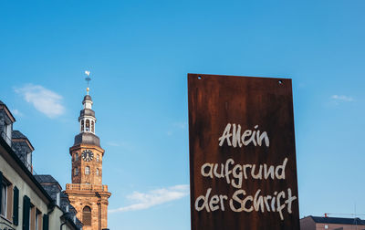 Low angle view of text on building against sky