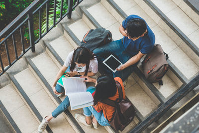 High angle view of people sitting on staircase