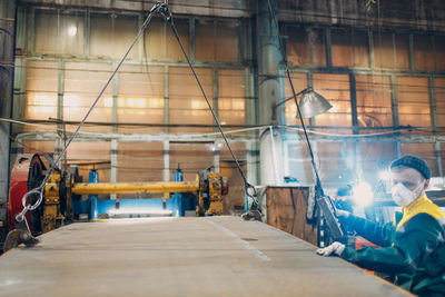 Rear view of man standing in factory