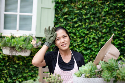 Portrait of woman standing against plants in yard