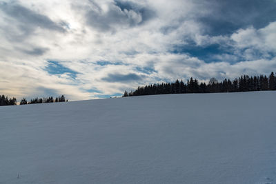 Scenic view of snow covered land against sky