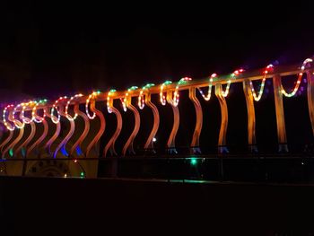 Close-up of illuminated lights against sky at night