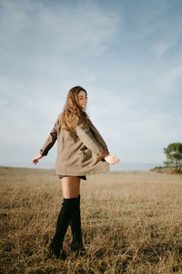 Woman standing on field against sky