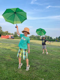 Rear view of woman with umbrella on field