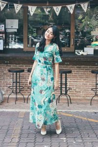 Full length of woman standing against cafe