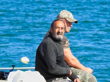 Portrait of man sitting by sea