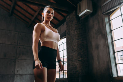 Low angle view of woman standing against wall