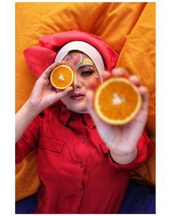 Midsection of man holding orange fruit