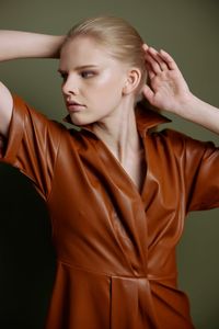 Portrait of young woman against black background