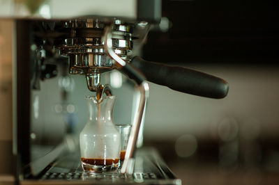 Close-up of coffee pouring in jug at cafe