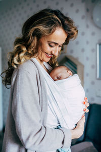 Happy woman with baby girl sitting at home