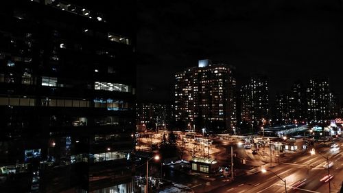 Illuminated cityscape against sky at night