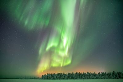 Scenic view of illuminated landscape against sky at night