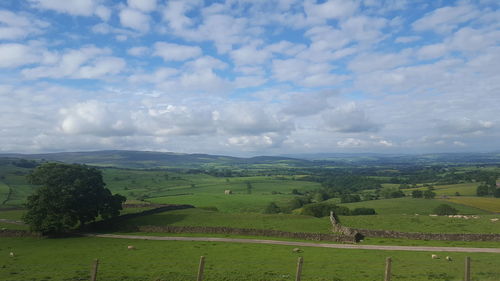 Scenic view of field against cloudy sky