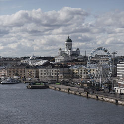 View of cityscape against cloudy sky