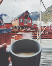 Hand holding coffee cup by building