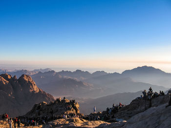 Panoramic view of people on mountain against clear sky