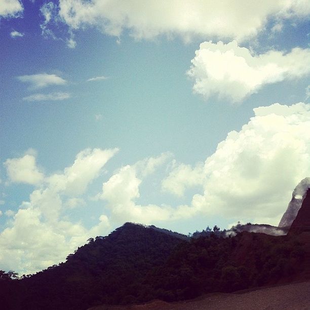 sky, cloud - sky, low angle view, cloud, tranquility, tranquil scene, nature, cloudy, blue, built structure, scenics, beauty in nature, mountain, tree, landscape, day, architecture, outdoors, no people, building exterior