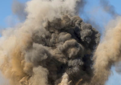 Dust and smoke clouds after powerful detonator blast on the mining site in arabian desert 